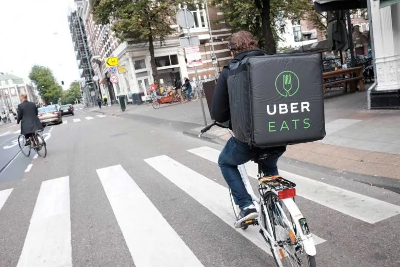 Entregador de bicicleta com mochila de aplicativo de delivery